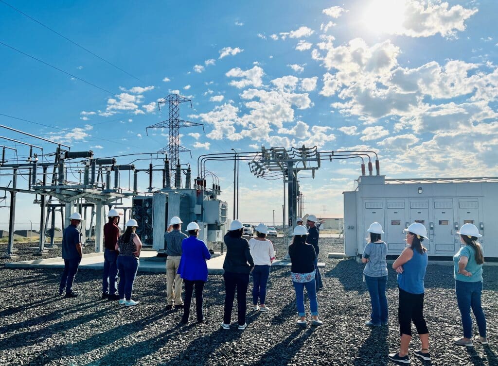 A group of people wearing hard hats standing outside