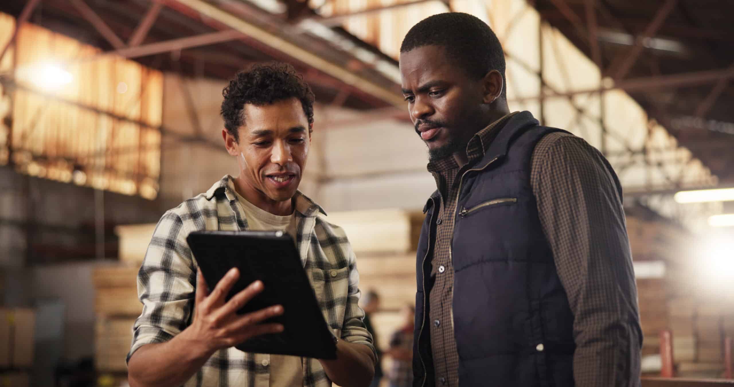 Colleagues in a woodworking business looking at a tablet together