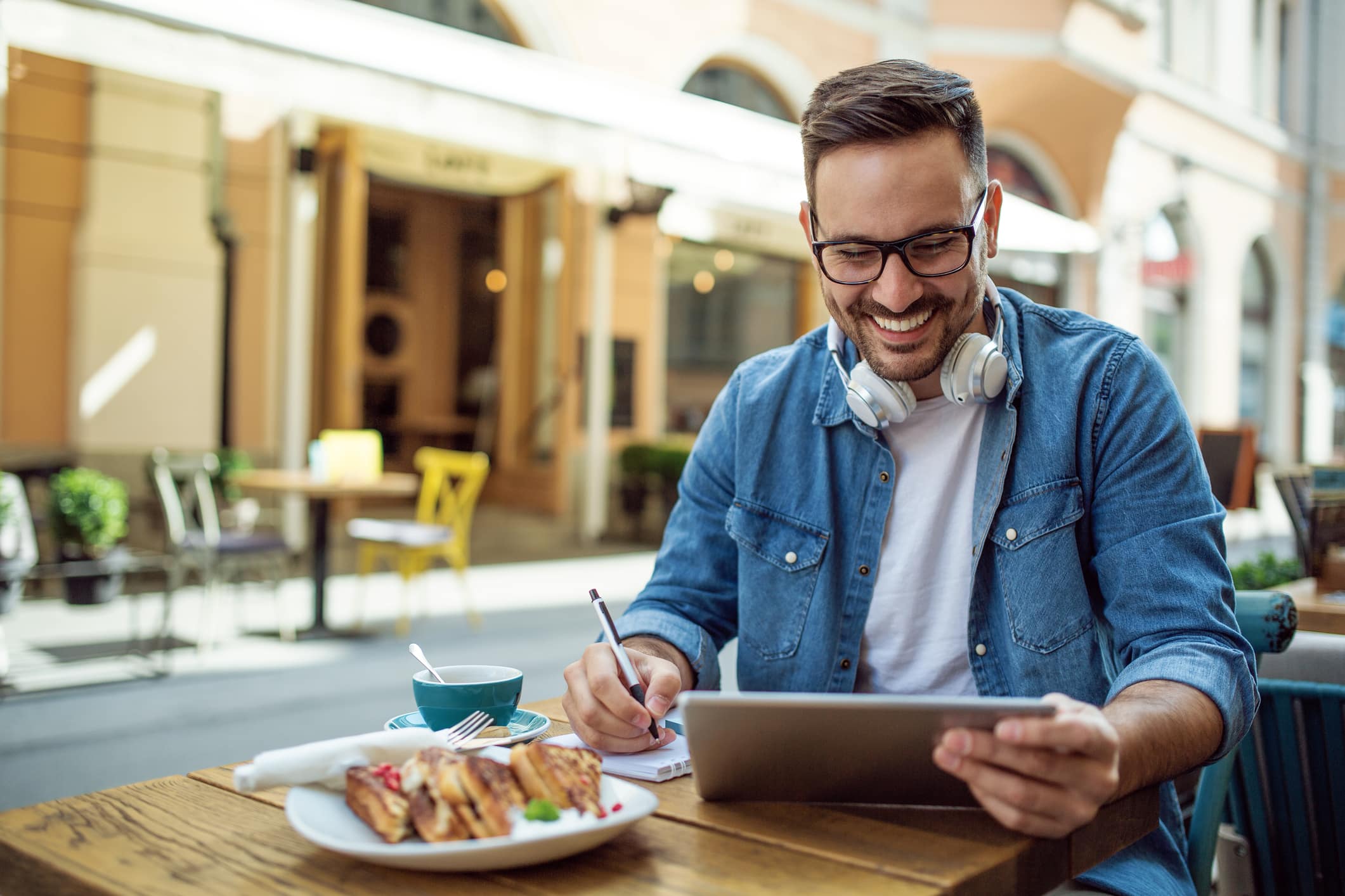 Smiling person using tablet at cafe