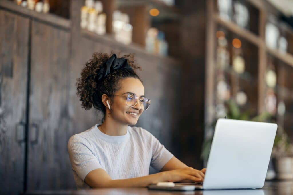 An employee works on a laptop in a modern retail setting.