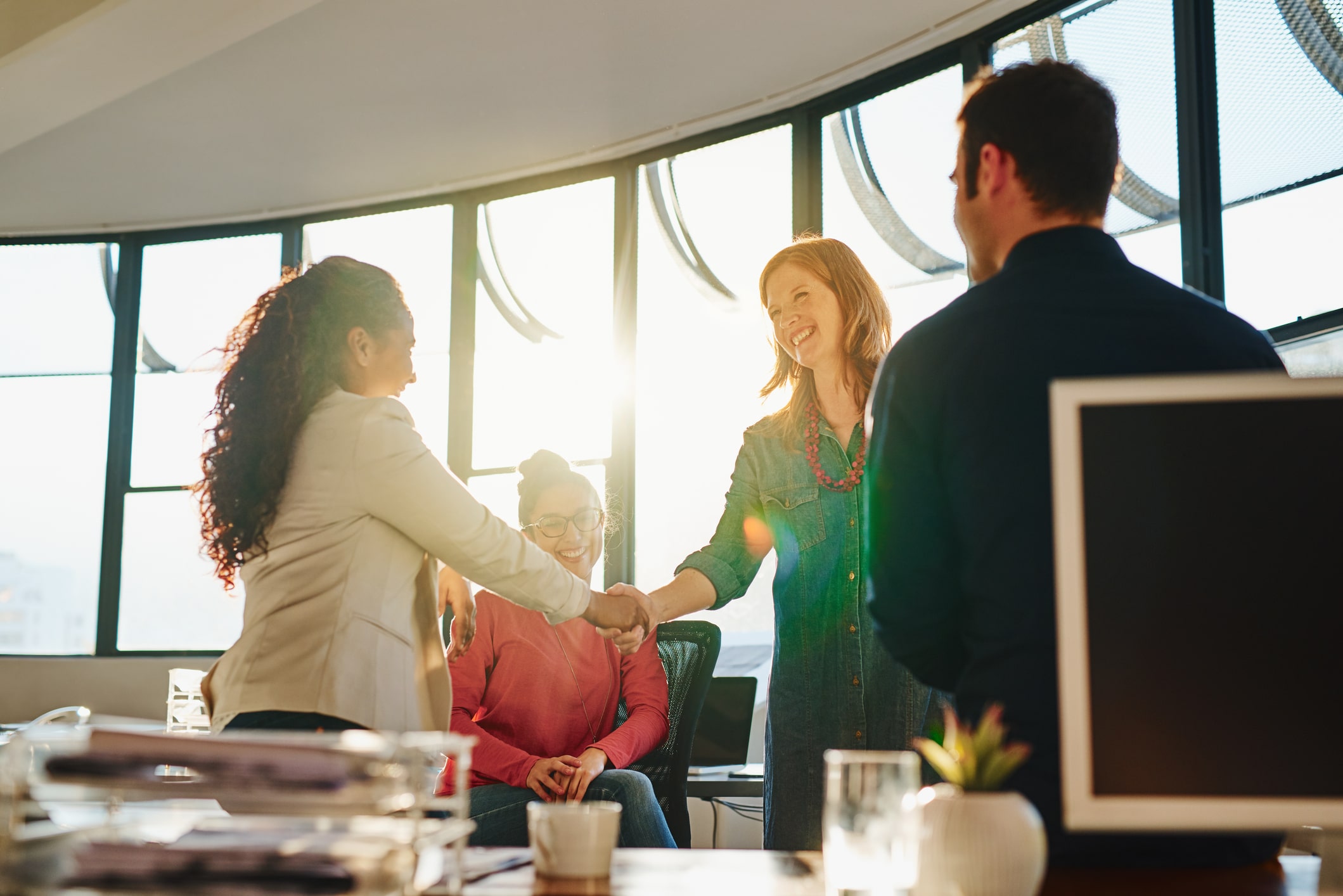 Professionals shaking hands during a meeting in an office