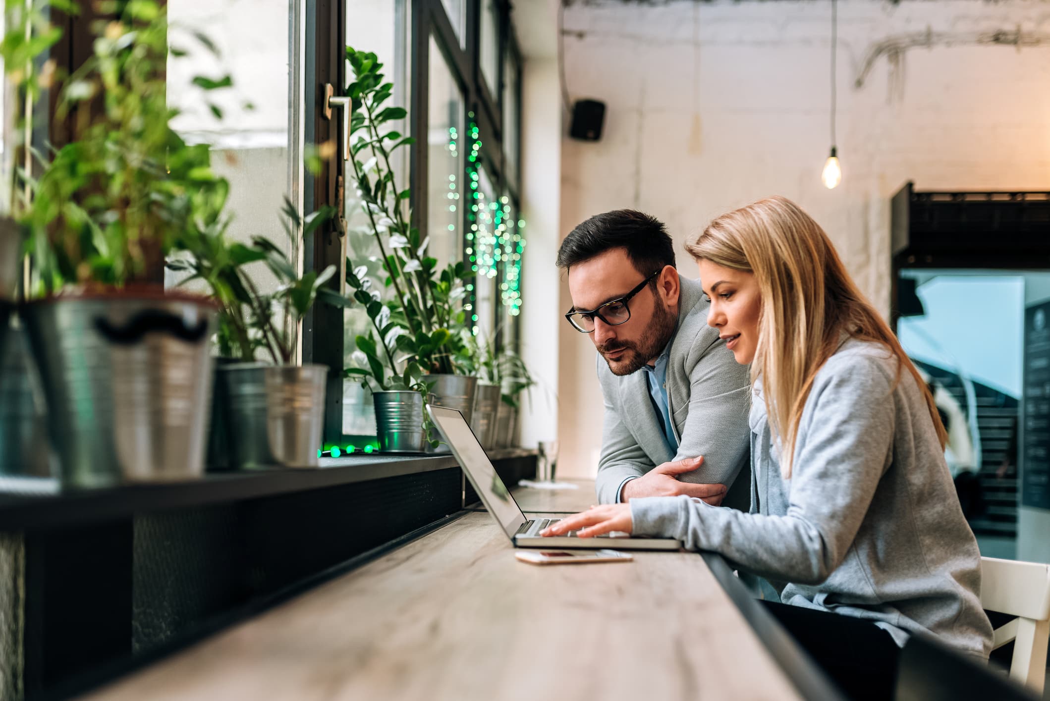 Colleagues working together on a laptop in cafe or coworking space