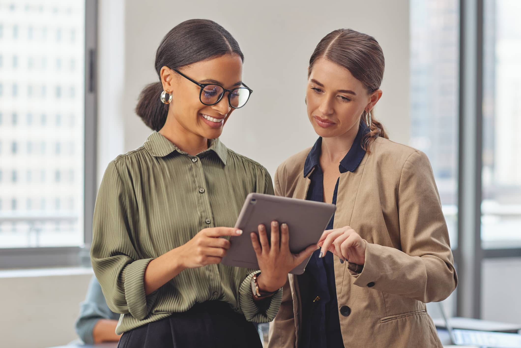 Shot of two colleagues using a digital tablet in a modern office