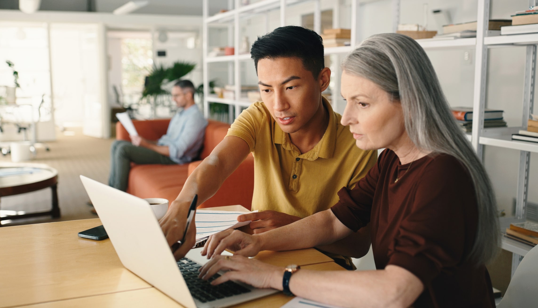 Colleagues discussing content on a laptop screen