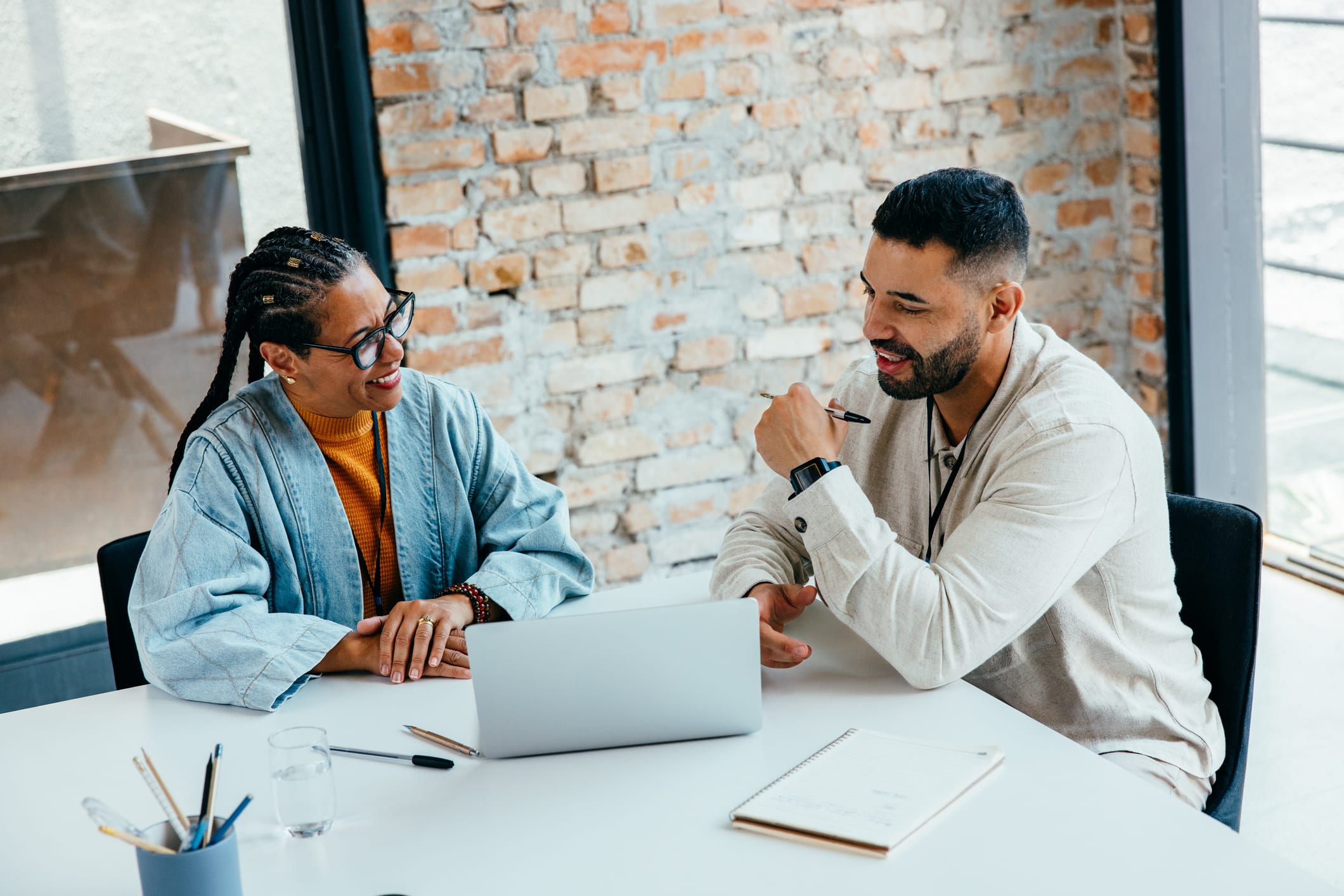 Colleagues collaborate in a team meeting, sharing ideas and developing a strategy in a bright, contemporary office environment.