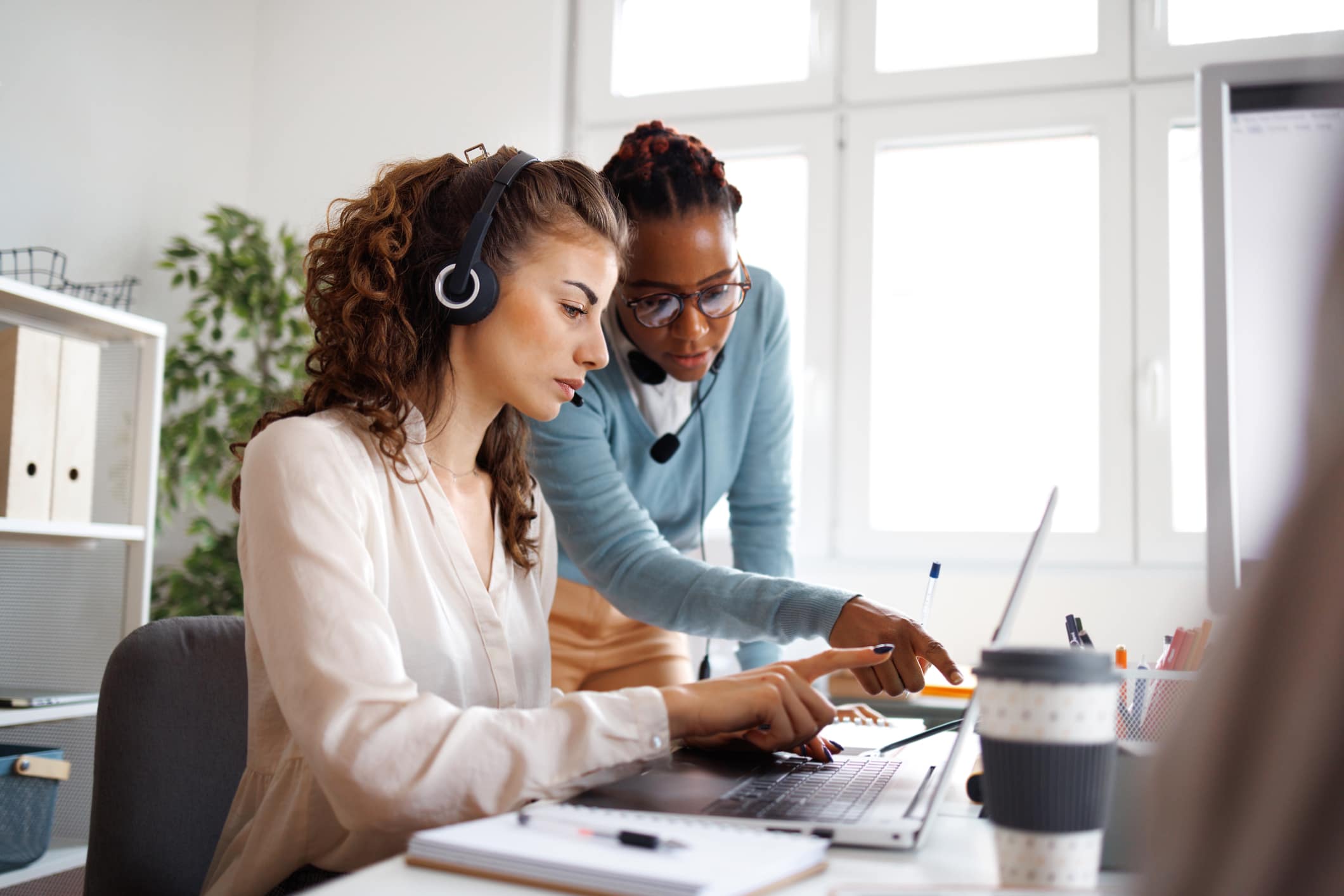 Two customer service team members reviewing information together in an office setting.