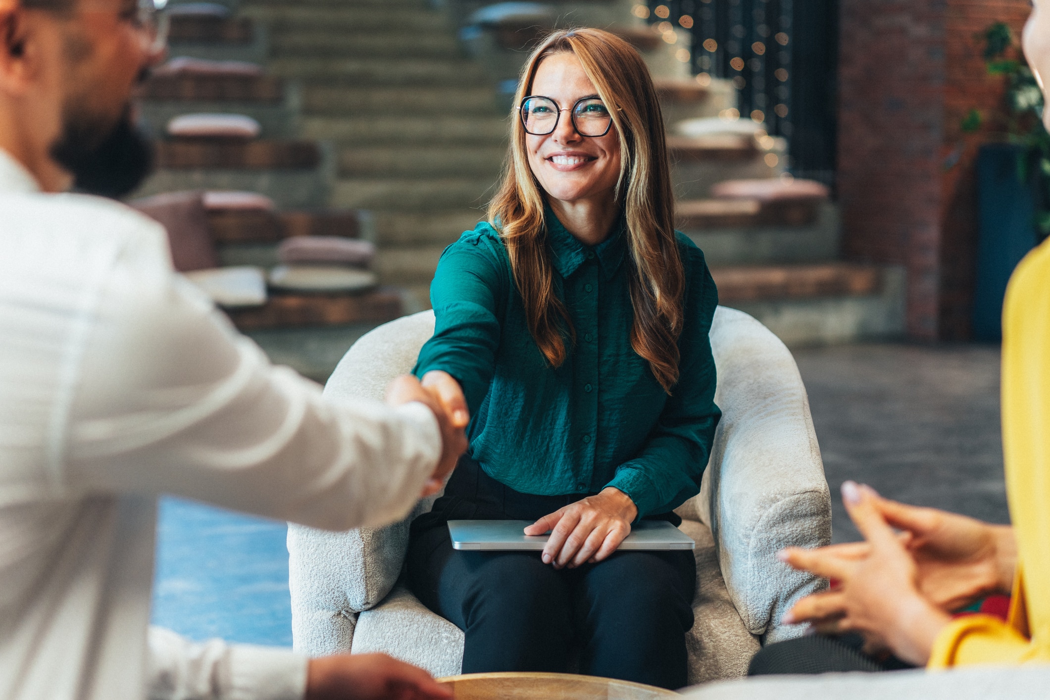 People in an office setting, greeting each other with a handshake