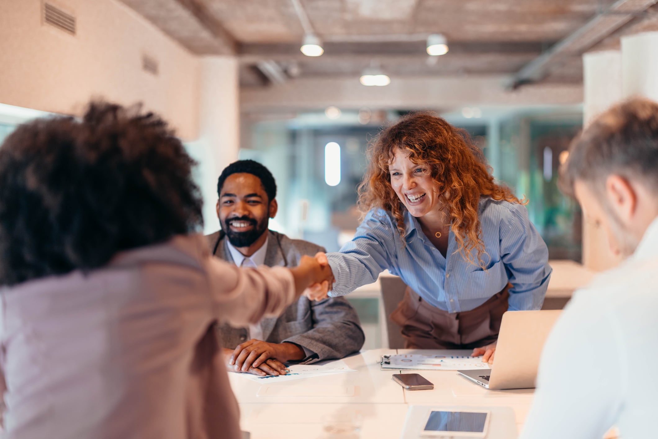Two businesspeople shaking hands in a modern office