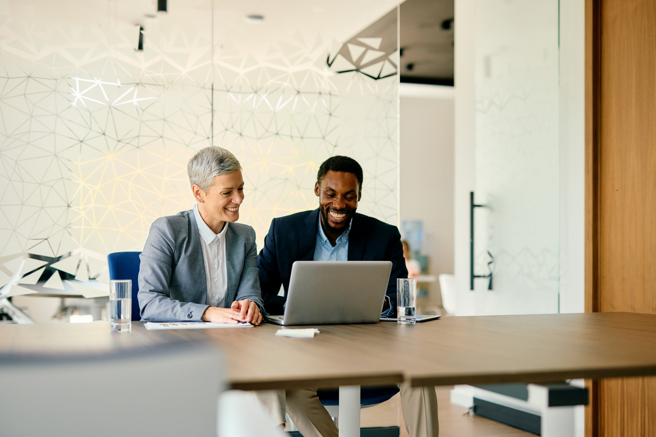 Two business professionals working together on a laptop.