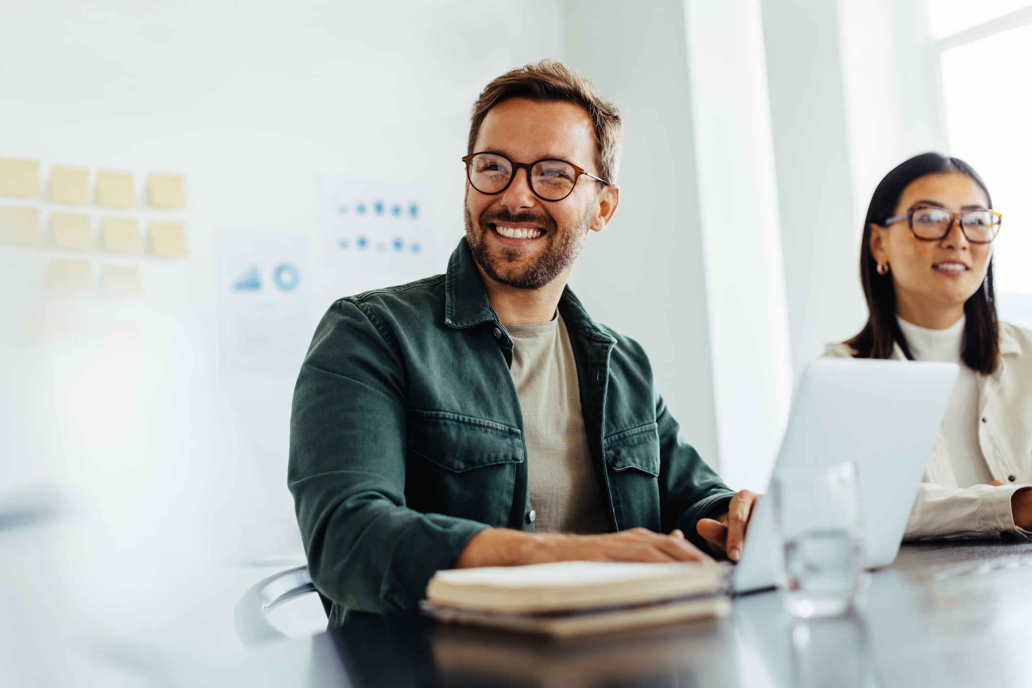 Smiling employee listening attentively during a work meeting in an office setting