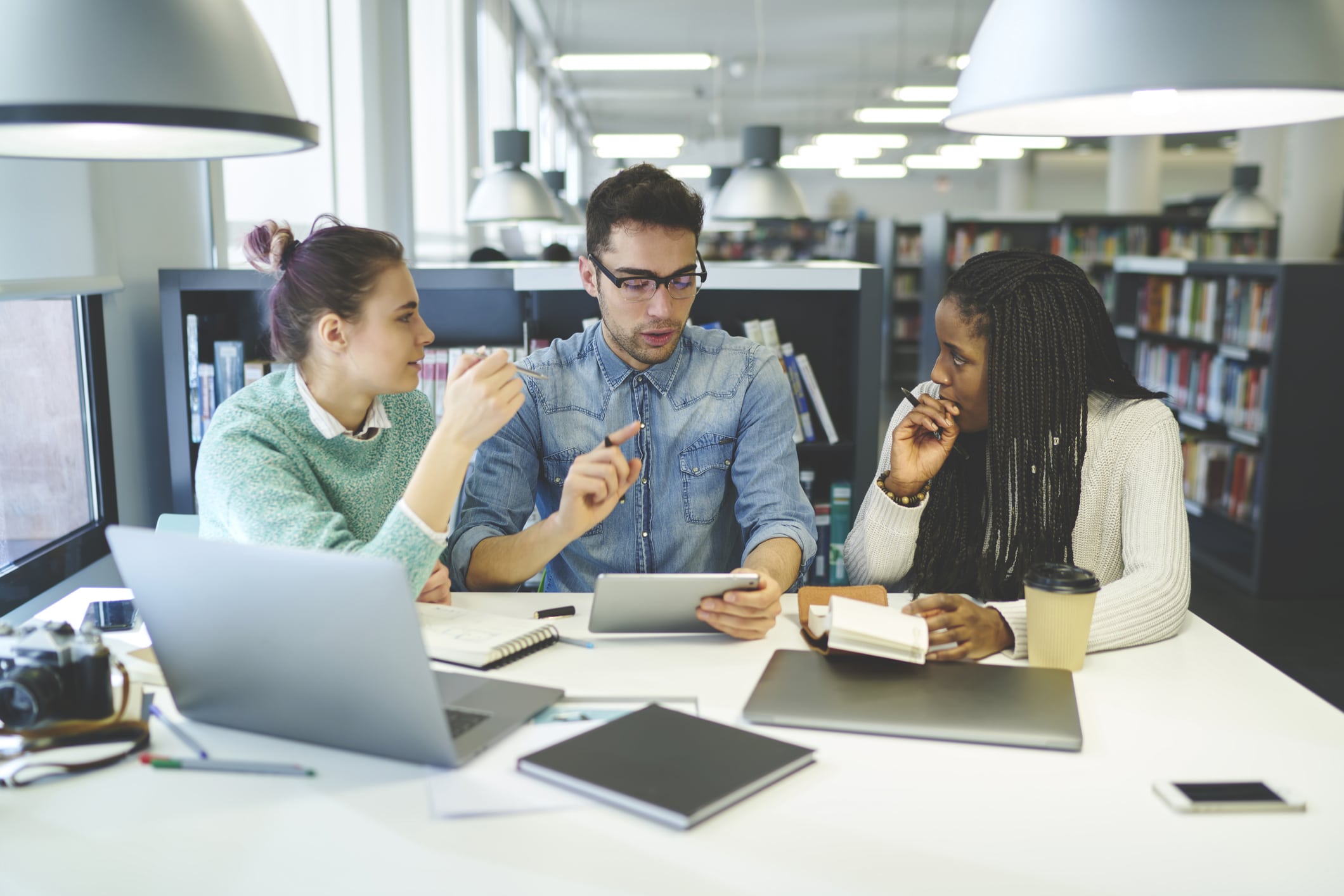 Informal meeting of three people in library setting